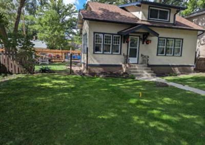 Exterior waterproofing crew sealing foundation wall during summer